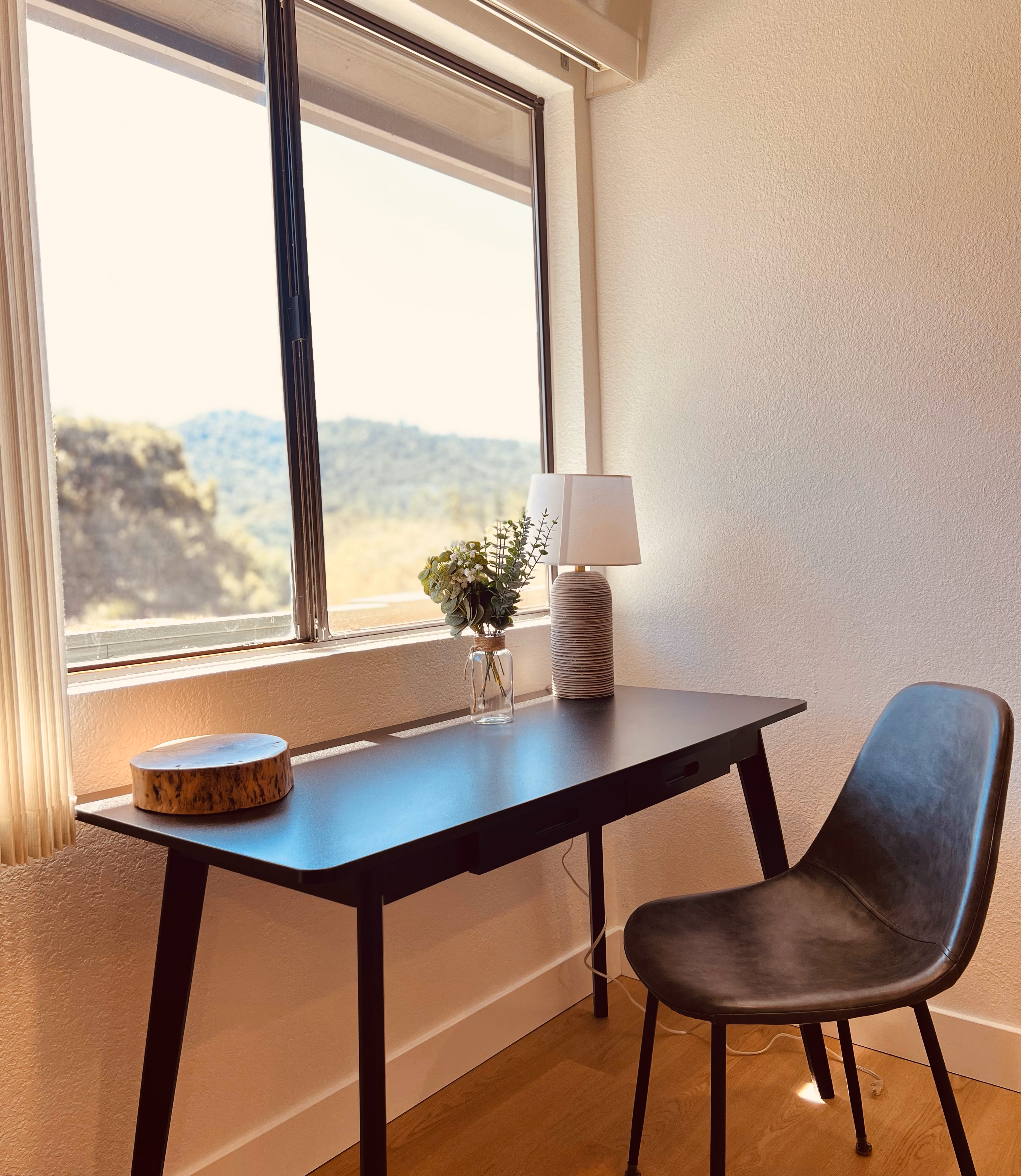 Writing desk beneath a window looking out over the Sierra foothills